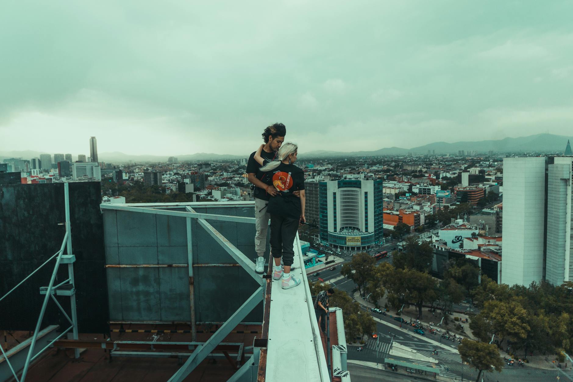 Młoda para na krawędzi wieżowca z panoramą Mexico City