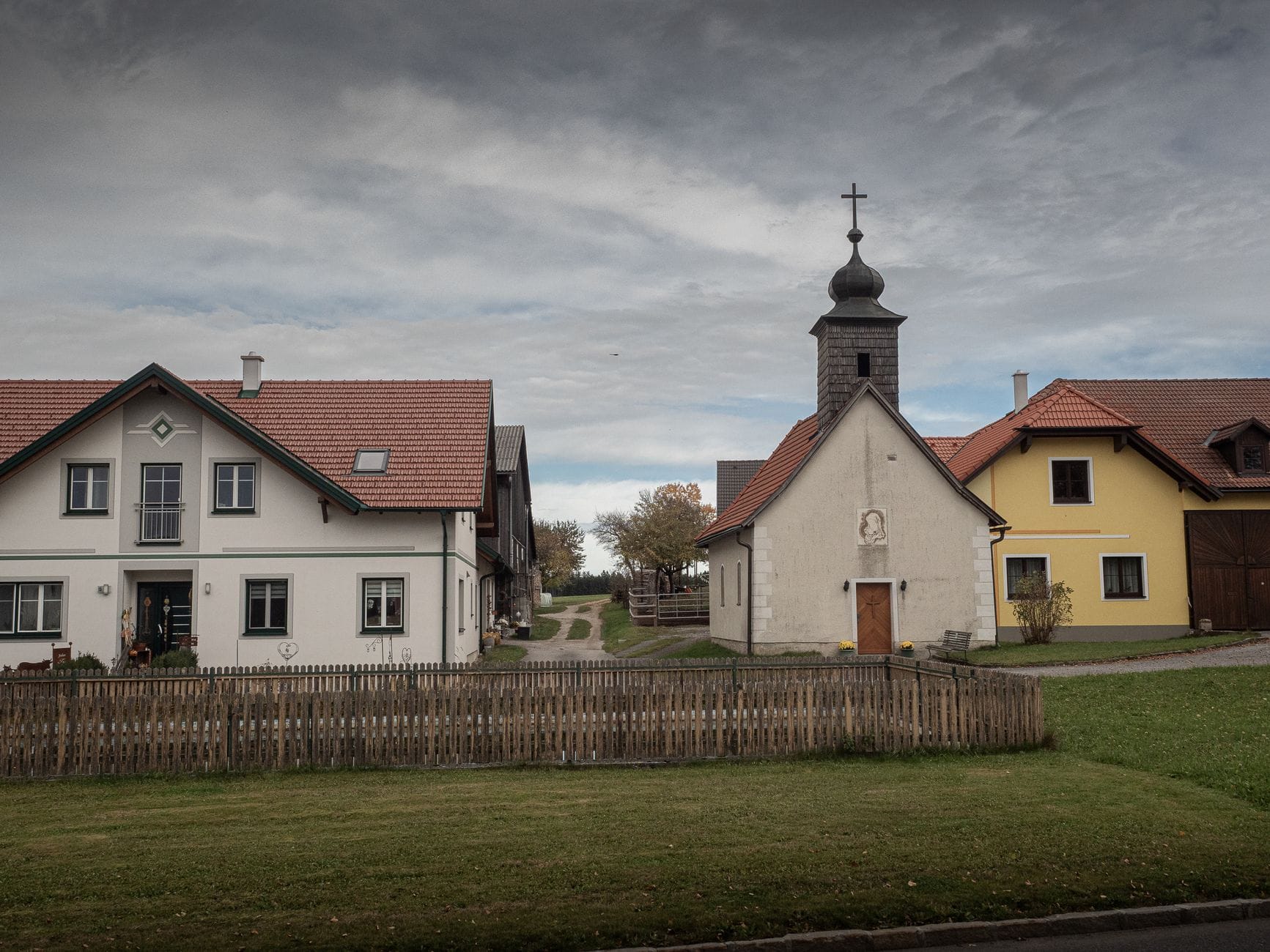 Europejskie miasteczko z kaplicą i domami pod zachmurzonym niebem