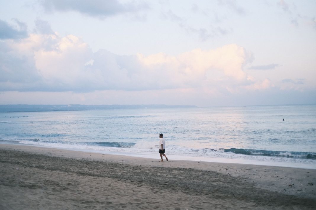 Samotny spacer po plaży na Bali o zachodzie słońca