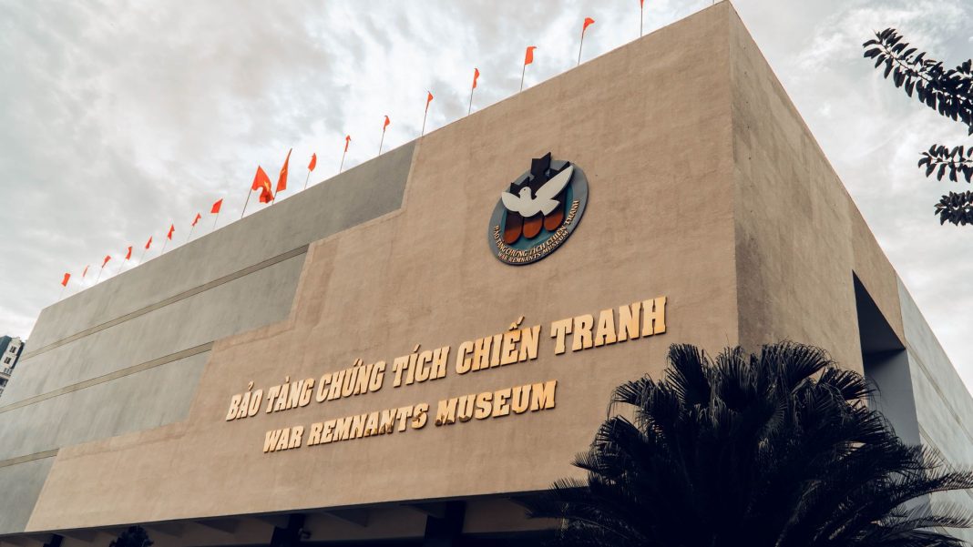 Muzeum Pozostałości Wojny w Ho Chi Minh widziane z dołu, flagi i szyld